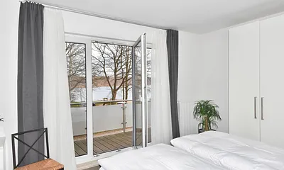 Schlafzimmer mit Balkonzugang und Seeblick