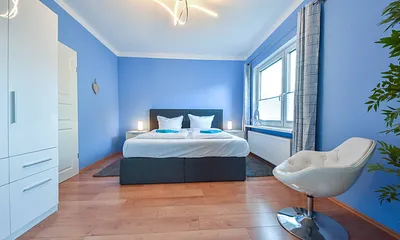 Hauptschlafzimmer mit Boxspringbett und Clubsessel