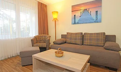 Wohnzimmer mit Couch (Aufbettung für 3./4. Person, 1,50 m  x 2,00 m), Couchtisch, Leselampe, Smart-TV, Radio mit CD-Player