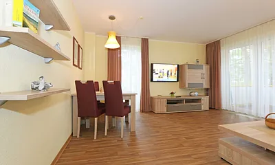 Wohnzimmer mit Couch (Aufbettung für 3./4. Person, 1,50 m  x 2,00 m), Couchtisch, Leselampe, Smart-TV, Radio mit CD-Player