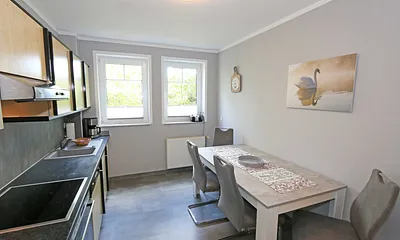 separate Küche mit 4-Herdplatten, Backofen, Mikrowelle, Geschirrspüler, Kühlschrank und diversen Küchenutensilien