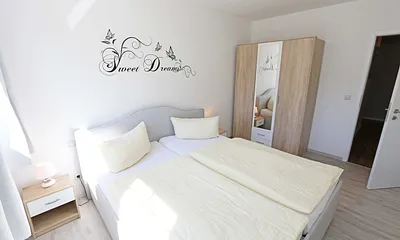 Schlafzimmer mit Doppelbett und Kleiderschrank