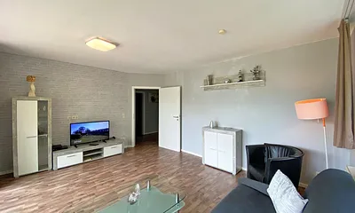 Wohnzimmer mit Schlafcouch (Aufbettung 3./4. Person, 1,60 m x 2,00 m), Sessel, TV sowie Blu-Ray-Player