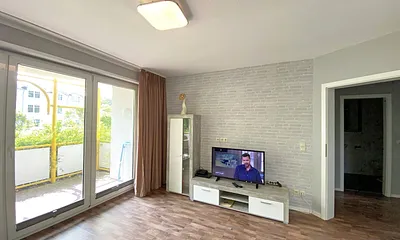 Wohnzimmer mit Schlafcouch (Aufbettung 3./4. Person, 1,60 m x 2,00 m), Sessel, TV sowie Blu-Ray-Player