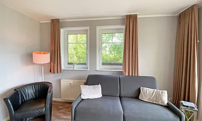 Wohnzimmer mit Schlafcouch (Aufbettung 3./4. Person, 1,60 m x 2,00 m), Sessel, TV sowie Blu-Ray-Player