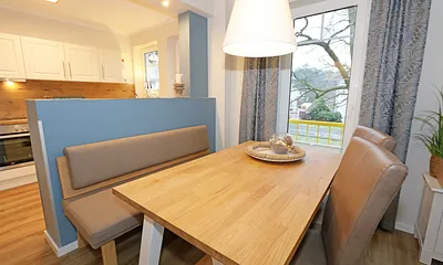 angrenzender Essbereich mit Tisch, Stühlen und einer Sitzbank