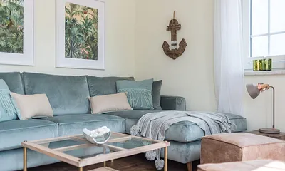 Wohnbereich mit Couch, Couchtisch, Sessel, Leselampe, Sideboard, Smart-TV, DAB Radio, Blu Ray Player sowie durchgängige Fensterfront mit fantastischem Panorama- und Meerblick