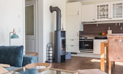 Wohnbereich mit Couch, Couchtisch, Leselampe, Sideboard, Smart-TV, DAB Radio, Blu Ray Player sowie durchgängige Fensterfront mit fantastischen Panorama- und Meerblick