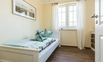 Schlafzimmer befindet sich ein Einzelbett (0,90 m x 2,00 m), ein Sessel sowie eine kleine Kommode