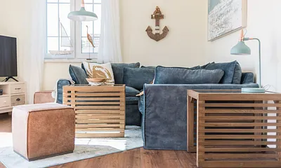 Wohnbereich mit Couch, Couchtisch, Leselampe, Sideboard, Smart-TV, DAB Radio, Blu Ray Player sowie durchgängige Fensterfront mit fantastischen Panorama- und Meerblick