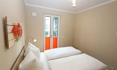 Schlafzimmer mit Doppelbett (1,60 m x 2,00 m), 2 Nachttischablagen, Kleiderablage und Drehtürenschrank