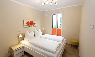 Schlafzimmer mit Doppelbett (1,60 m x 2,00 m), 2 Nachttischablagen, Kleiderablage und Drehtürenschrank