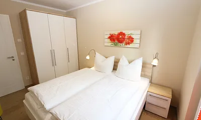 Schlafzimmer mit Doppelbett (1,60 m x 2,00 m), 2 Nachttischablagen, Kleiderablage und Drehtürenschrank