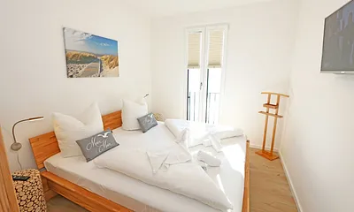 Schlafzimmer mit Doppelbett (1,80 m x 2,00 m), verstellbare Lattenroste, Nachttischablagen, Kleiderschrank mit Spiegelfront, Verdunklungsmöglichkeiten, Plissees sowie Insektenschutzgitter & Smart TV