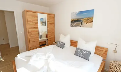 Schlafzimmer mit Doppelbett (1,80 m x 2,00 m), verstellbare Lattenroste, Nachttischablagen, Kleiderschrank mit Spiegelfront, Verdunklungsmöglichkeiten, Plissees sowie Insektenschutzgitter & Smart TV