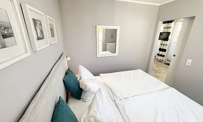 Schlafzimmer mit Boxspringbett, komfortabler Topper, Nachttischablagen sowie Verdunkelungsvorhang