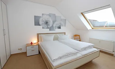Schlafzimmer mit Doppelbett (1,80 m x 2,00 m), Nachttischablagen, Kleiderschrank sowie einen weiteren Smart-TV welcher aber nur zum Streamen genutzt werden kann