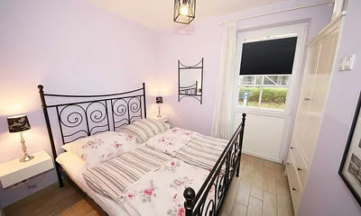 Schlafzimmer mit einem Doppelbett (1,60 m x 2,00 m), Qualitäts- Latexmatratzen, verstellbarem Lattenrost, Kleiderschrank und Verdunklungsplissees 