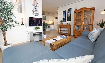 gemütlicher Wohnbereich mit Ecksofa, Glasvitrine mit Büchern und Gesellschaftsspielen, Leselampe, Smart-TV mit Blu Ray-Player, DAB Radio und CD-Player