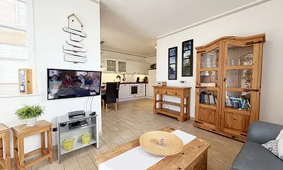 gemütlicher Wohnbereich mit Ecksofa, Glasvitrine und Smart-TV