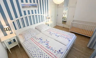 Schlafzimmer mit einem Doppelbett (1,80 m x 2,00 m), Qualitäts- Latexmatratzen, verstellbarem Lattenrost, Kleiderschrank und Verdunklungsplissees 