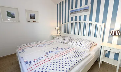 Schlafzimmer mit einem Doppelbett (1,80 m x 2,00 m), Qualitäts- Latexmatratzen, verstellbarem Lattenrost, Kleiderschrank und Verdunklungsplissees 