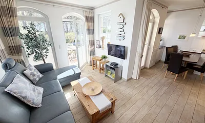 gemütlicher Wohnbereich mit Ecksofa, Glasvitrine und Smart-TV