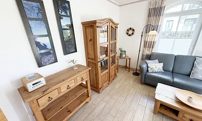 gemütlicher Wohnbereich mit Ecksofa und Vitrine