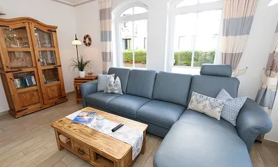 gemütlicher Wohnbereich mit Ecksofa, Glasvitrine mit Büchern und Gesellschaftsspielen, Leselampe, Smart-TV mit Blu Ray-Player, DAB Radio und CD-Player