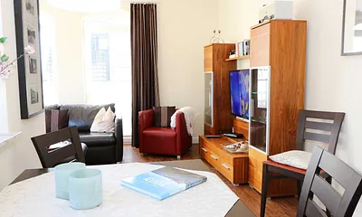 gemütliche Sitzecke bestehend aus Ledercouch (ausklappbar 1,40 m x 2,00 m mit Lattenrost und Matratze) und zwei Sesseln, Leselampe, Smart-TV.