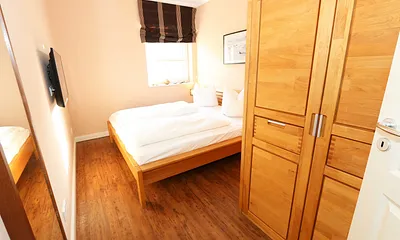Schlafzimmer mit Doppelbett und Kleiderschrank