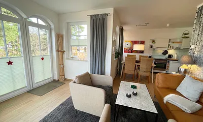 Wohnzimmer mit gemütlicher Sitzecke, Leselampe, Smart-TV, DVD-Player und Telefon