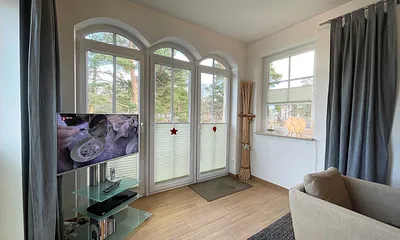 Wohnzimmer mit gemütlicher Sitzecke, Leselampe, Smart-TV, DVD-Player und Telefon