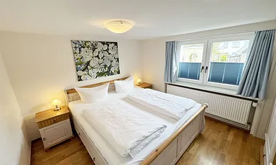 Schlafzimmer mit Doppelbett und Nachtschränken