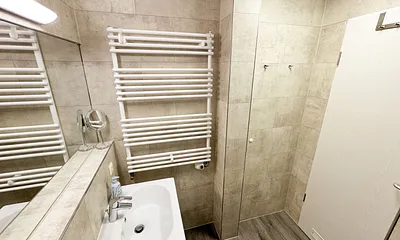 innenliegendes Badezimmer mit WC, Dusche (80 m x 75 m), Waschtisch mit Ablagemöglichkeit, Fön, Kosmetikspiegel, großem Wandspiegel und Handtuchheizkörper