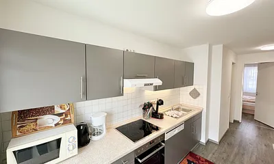 Küchenzeile mit 4 Zonencerankochfeld, Geschirrspüler, Backofen, Kühlschrank mit Gefrierfach, Toaster, Mikrowelle, Wasserkocher, Kaffeemaschine sowie Dolce Gusto Kapselmaschine