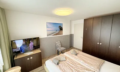 Wohn/Schlafbereich mit 43 Zoll Smart TV,Doppelbett mit Einzelmatratzen (1,80 m x 2,00 m),Nachttischablagen mit Leselampen,geräumigen Kleiderschrank mit Safe,Sideboard mit Mini-Stereoanlage