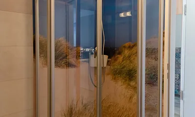 innenliegendes Badezimmer mit WC, Dusche, Waschtisch mit Unterschrank, Fön, Kosmetikspiegel, großem Wandspiegel, Handtuchheizkörper und einem Ablageregal