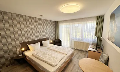 Wohn/Schlafbereich mit 43 Zoll Smart TV,Doppelbett mit Einzelmatratzen (1,80 m x 2,00 m), Nachttischablagen mit Leselampen, geräumiger Kleiderschrank mit Safe, Sideboard mit Mini-Stereoanlage