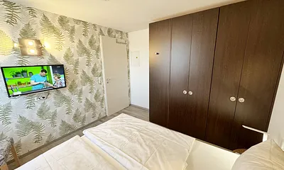 Schlafzimmer mit Doppelbett ( 2 x 0,90 m x 2,00 m ), Nachttischablagen mit Leselampen, Kleiderschrank mit Safe und Verdunklungsgardinen sowie Insektenschutzgitter