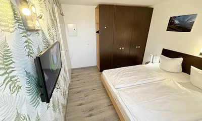Schlafzimmer mit Doppelbett ( 2 x 0,90 m x 2,00 m ), Nachttischablagen mit Leselampen, Kleiderschrank mit Safe und Verdunklungsgardinen sowie Insektenschutzgitter