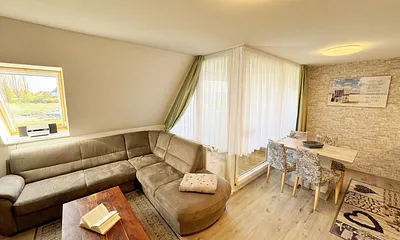 offener Wohnbereich mit Eckcouch, ein Sessel, Stehlampe, Sessel, Couchtisch, 48 Zoll Smart-TV, Hifi Microanlage mit CD-Player, MP3, UKW-Funktion, USB und Bluetooth mit NFC und ein DAB-Radio