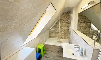 Badzimmer mit ebenerdiger Dusche (1,70 m x 0,90 m), WC, Waschtisch, Fön, großer Wandspiegel, Handtuchheizkörper und Ablageregal