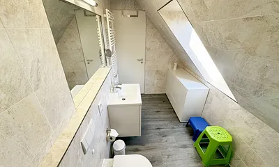Badzimmer mit ebenerdiger Dusche (1,70 m x 0,90 m), WC, Waschtisch, Fön, großer Wandspiegel, Handtuchheizkörper und Ablageregal