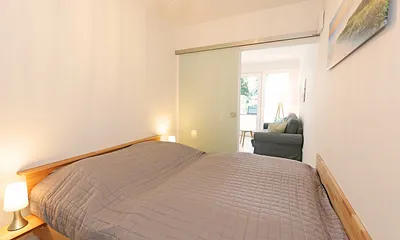 Schlafzimmer mit Doppelbett (1,60 m x 2,00 m), zwei 7-Zonen-Kaltschaummatratzen, Nachttischablagen und Einbauschrank