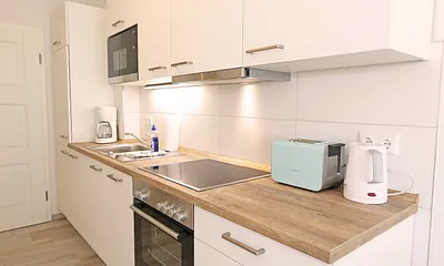 Küchenzeile mit Kühlschrank und Gefrierfach, Geschirrspüler, 4 Zonen Ceranfeld mit Backofen, Mikrowelle, Kaffeemaschine, Wasserkocher, Toaster, Mixer sowie diversen Küchenutensilien