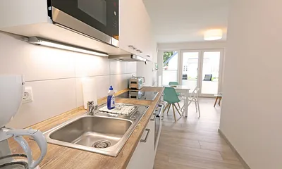 Küchenzeile mit Kühlschrank und Gefrierfach, Geschirrspüler, 4 Zonen Ceranfeld mit Backofen, Mikrowelle, Kaffeemaschine, Wasserkocher, Toaster, Mixer sowie diversen Küchenutensilien