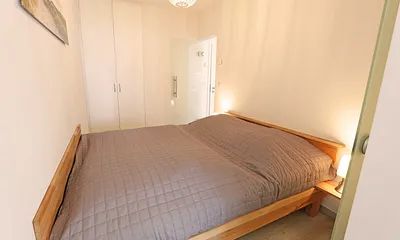 Schlafzimmer mit Doppelbett (1,60 m x 2,00 m), zwei 7-Zonen-Kaltschaummatratzen, Nachttischablagen und Einbauschrank