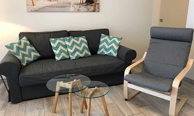 Wohnbereich mit Couch (voll funktionstüchtiges Bett mit Lattenrost und Matratze - Liegefläche 1,60 m x 2,00 m),Couchtisch,Sideboard,Leselampe,Flachbild-TV mit  Blu-Ray Player & Micro-Hifi System