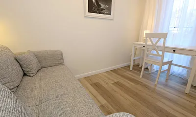 Schlafzimmer mit Funktionssofa (ausziehbare Liegefläche von 1,40 m x 2,00 m), umrahmt von Hängeschränke sowie einem Schreibtisch